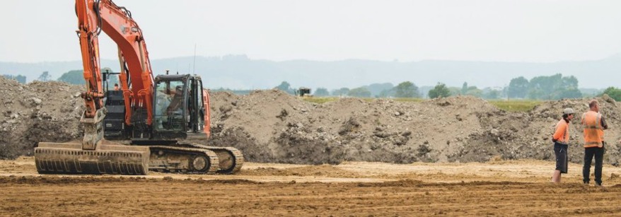 Four men consulting about earthworks in the Bay of Plenty region.