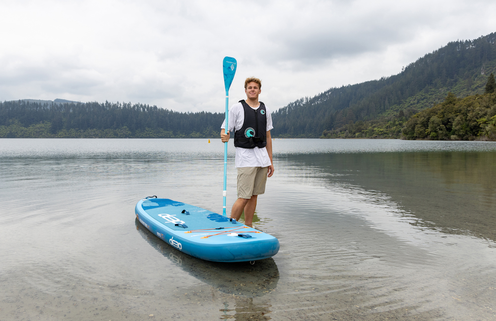 Man wearing lifejacket standing on paddle board